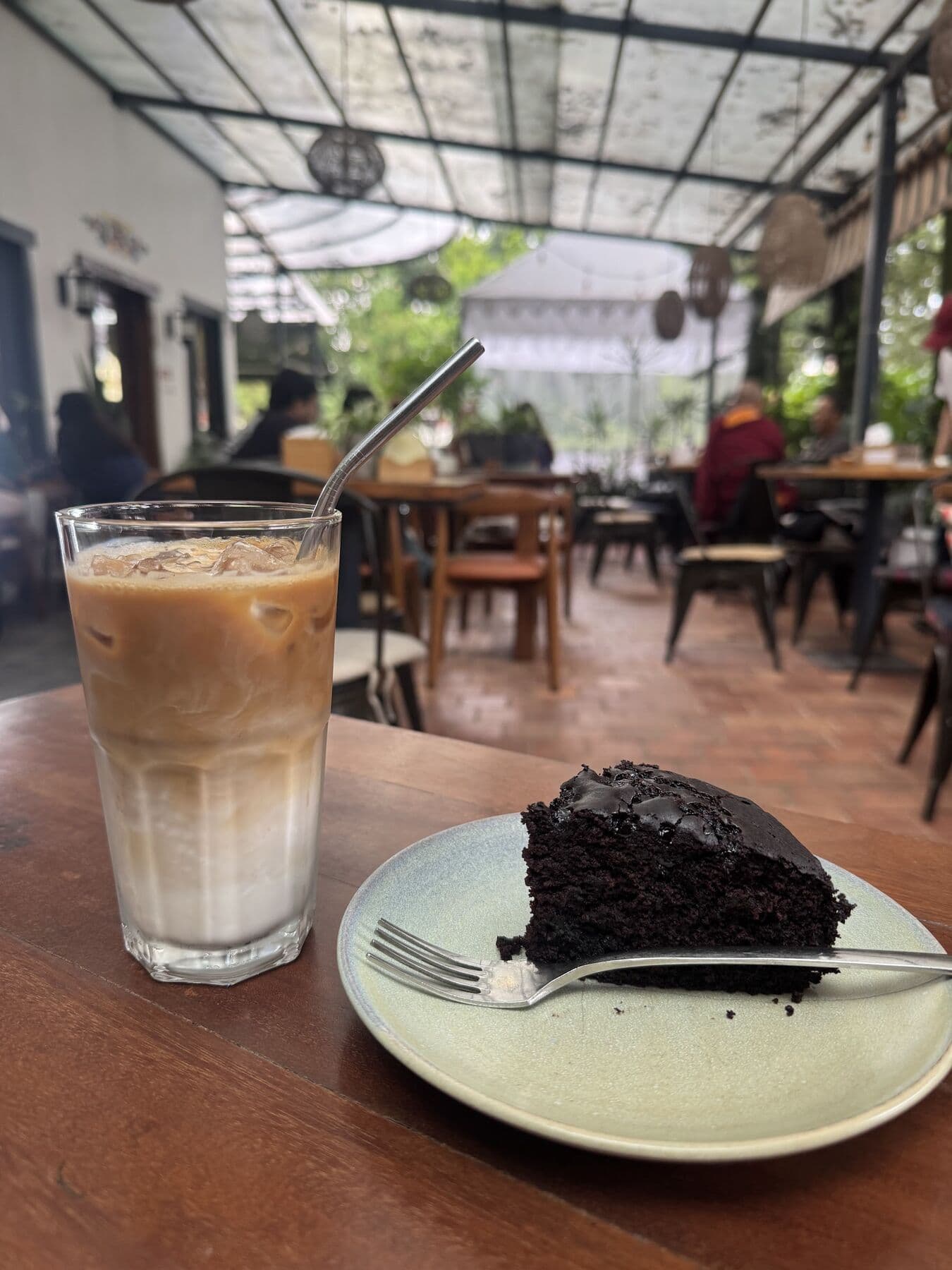 An iced latte and a slice of chocolate cake on the terrace